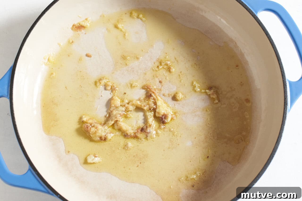 One-Pan Puttanesca Fish Recipe 5 Olive oil, grated garlic, and anchovies cooking in a skillet.