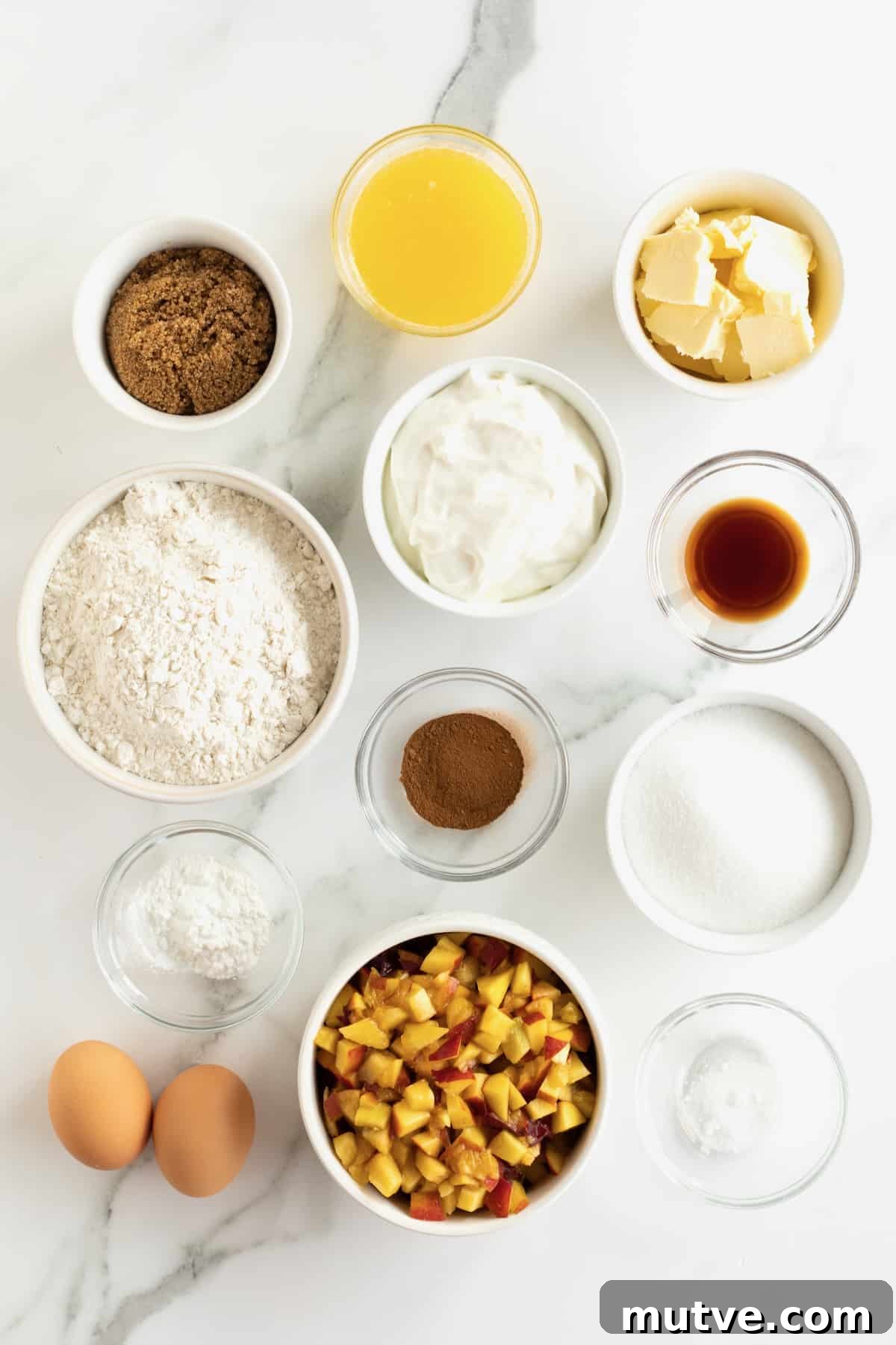 Peach Coffee Cake with Cinnamon Streusel 7 Butter, Granulated sugar, Dark brown sugar, Large eggs, Sour cream, Vanilla extract, All-purpose flour, Baking powder, Salt, Ground cinnamon, Chopped fresh peaches in small glass dishes on a white marble counter.