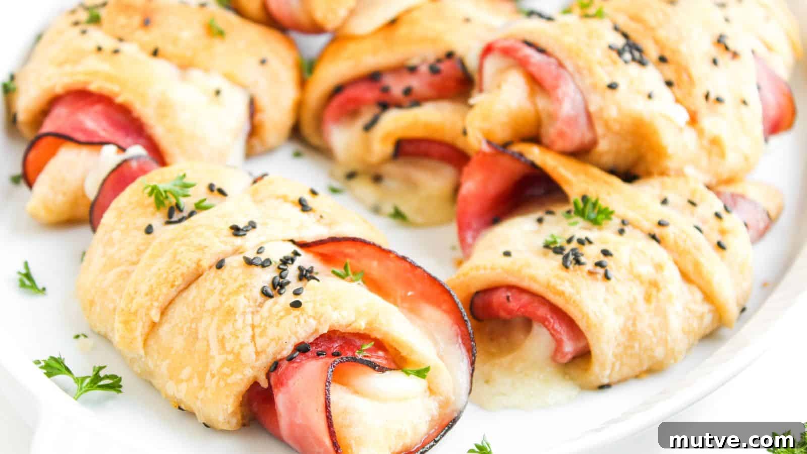 A plate of baked crescent rolls filled with slices of ham and melted cheese, topped with black sesame seeds and garnished with parsley.