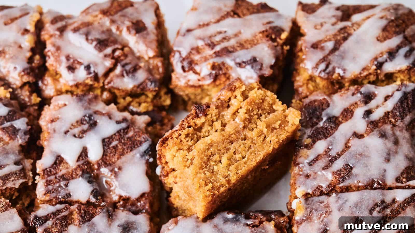 Close-up of sliced crumbly cakes topped with white icing. One piece is positioned vertically to show its texture.