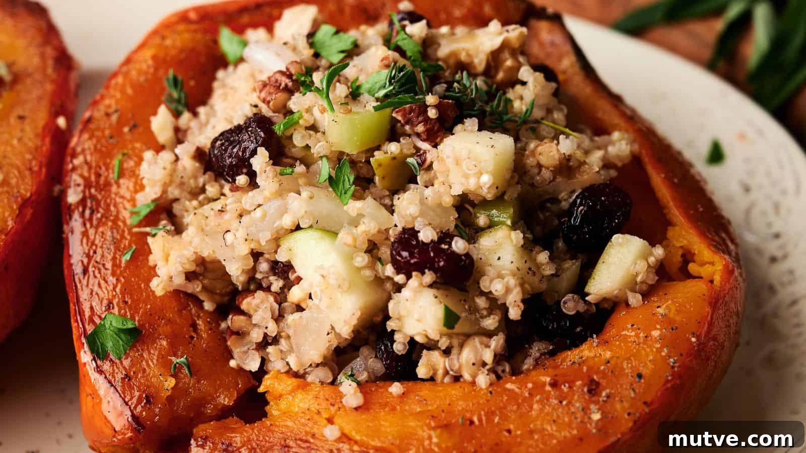 A roasted acorn squash half filled with a stuffing of couscous, apples, nuts, raisins, and fresh herbs sits on a plate.
