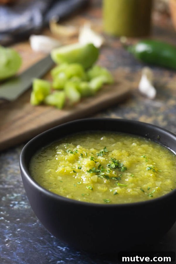 Green tomato salsa verde in a bowl with jalapenos and cilantro