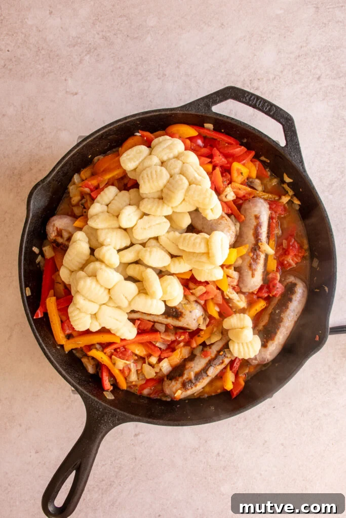 Skillet Gnocchi with Italian Sausage and Peppers 8 Adding gnocchi to the skillet with the sausages and peppers.