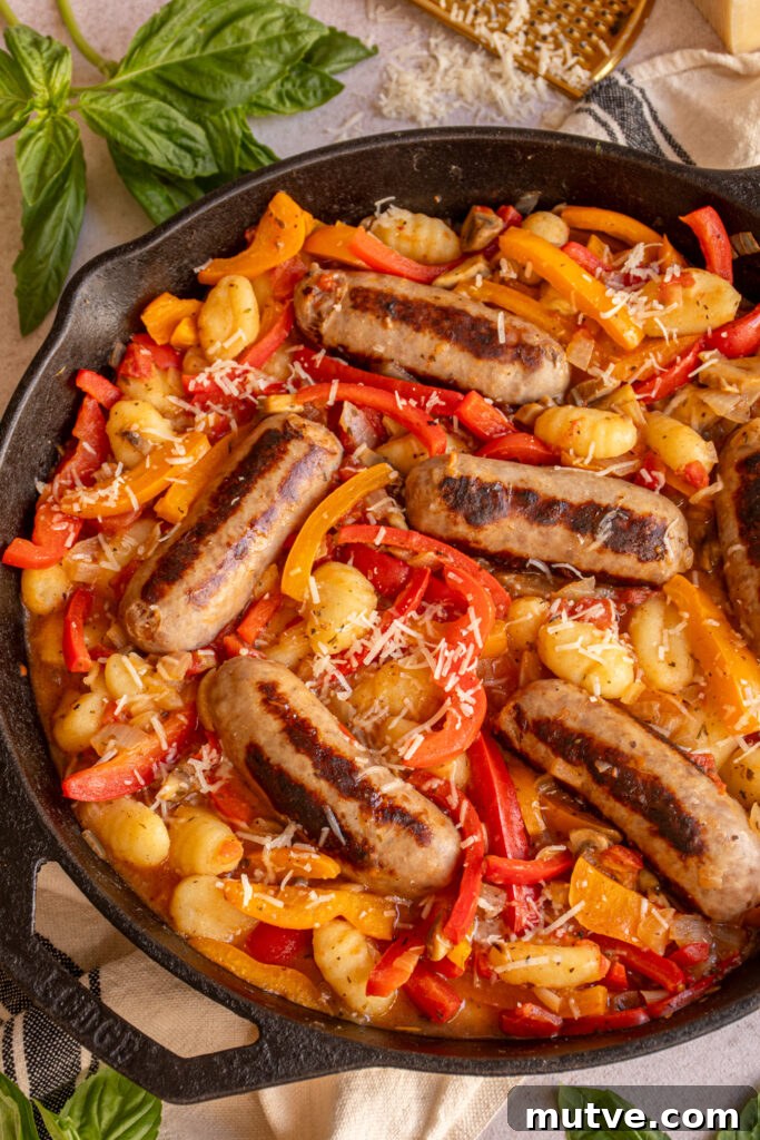 Skillet Gnocchi with Italian Sausage and Peppers 3 A close up of a large skillet with colorful bell peppers, gnocchi, and browned sausages.