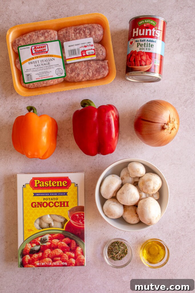 Skillet Gnocchi with Italian Sausage and Peppers 4 Ingredients to make gnocchi with sausages and peppers laid out on a table top.