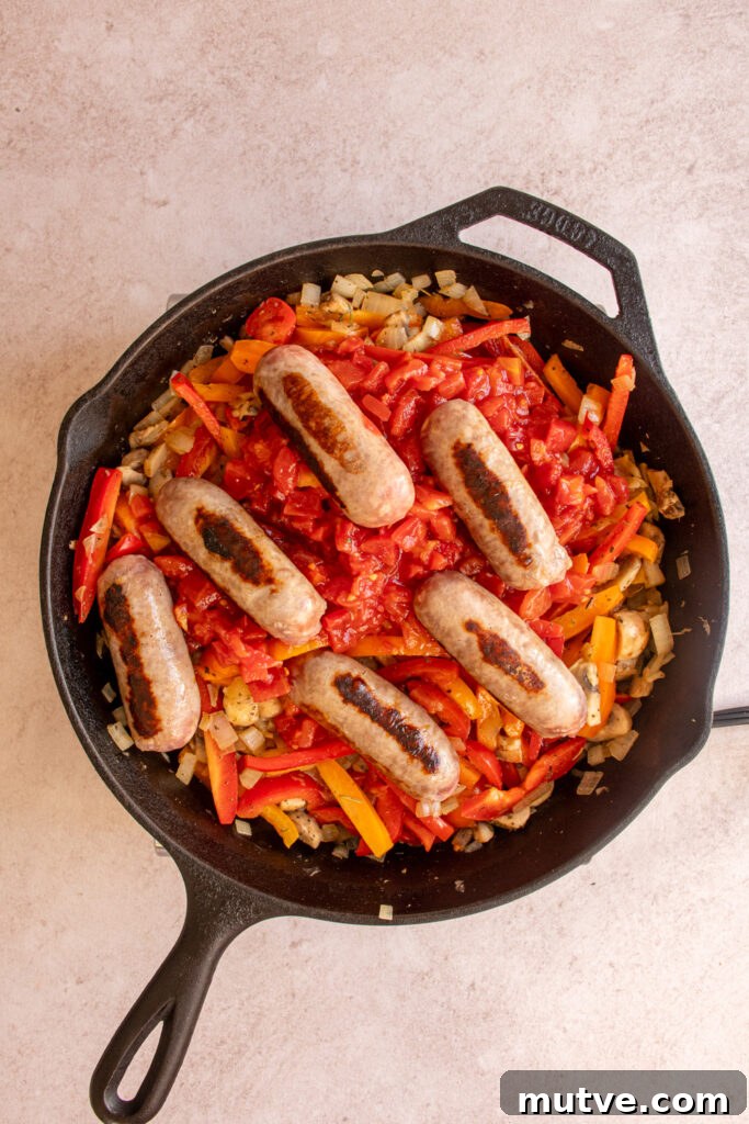 Skillet Gnocchi with Italian Sausage and Peppers 7 Adding the diced tomatoes and sausages to the skillet.