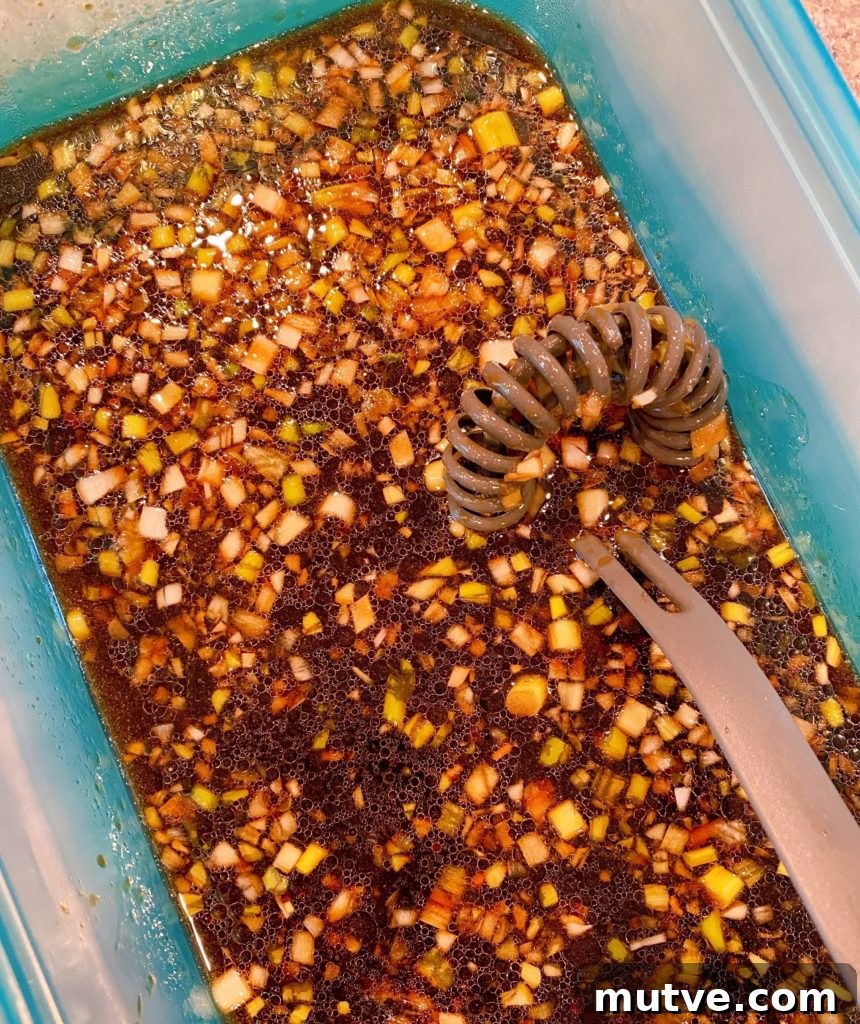 Kalbi Marinade with whisk in a large marinade container.