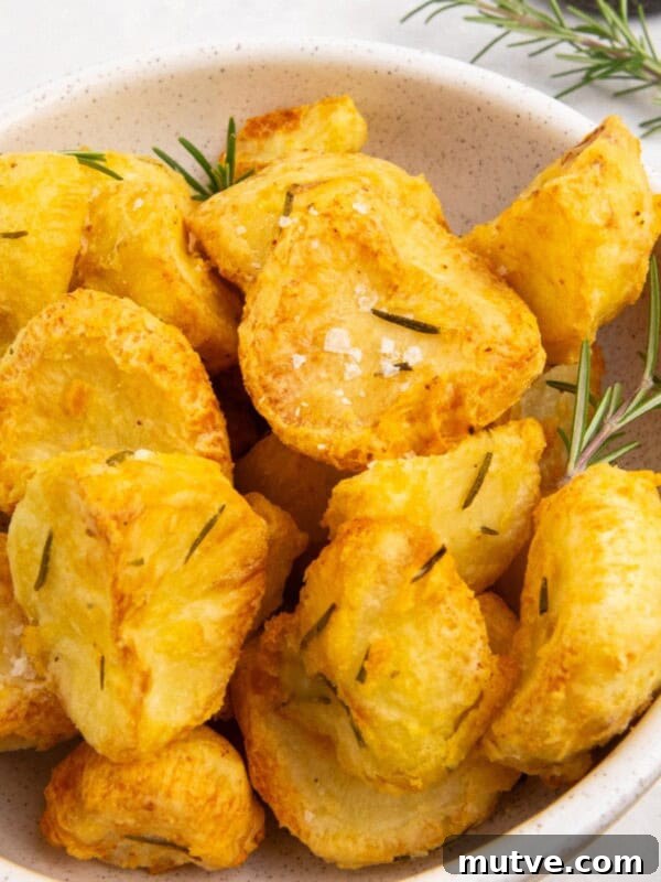 Crispy Air Fryer Broccoli in 10 Minutes 8 air fryer roast potatoes served in a white bowl with fresh rosemary.