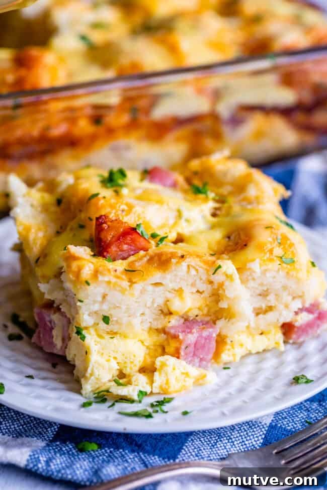Cheesy Biscuit-Topped Breakfast Casserole Recipe 12 a slice of ham, egg, and cheese biscuit casserole on a plate.