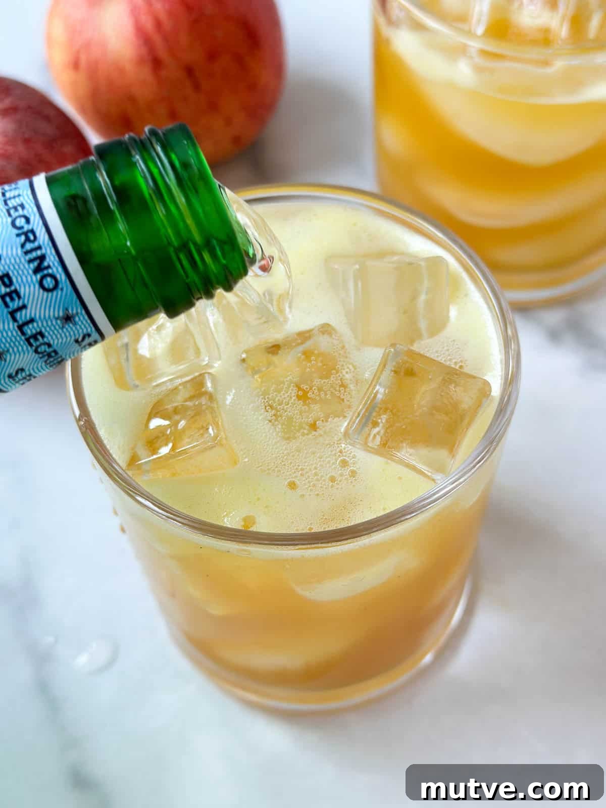 Ginger Turmeric Shots Recipe in a Blender 6 Pouring sparkling water over ginger turmeric juice to make a mocktail.