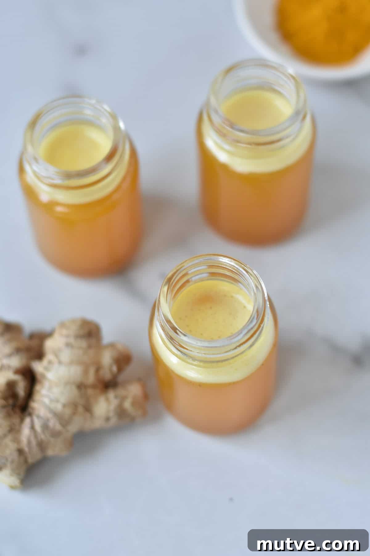 Ginger Turmeric Shots Recipe in a Blender 7 Overhead of glass jars filled with ginger turmeric juice.