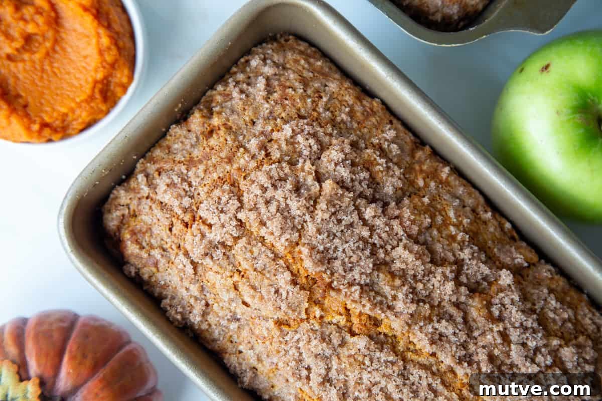 Cinnamon-Spiced Pumpkin Apple Bread 9 loaf of pumpkin apple bread in a loaf pan.