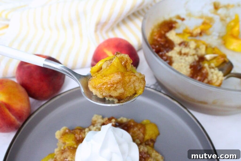 Quick Microwave Peach Crumble Recipe 3 holding up a spoonful of peach crumble made in the microwave