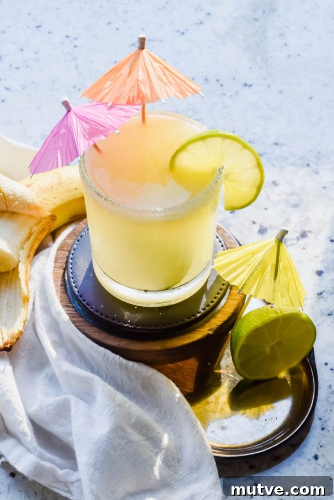 Banana Margarita Recipe: Creamy Tropical Cocktail 2 Banana Margarita cocktail in a glass with lime garnish