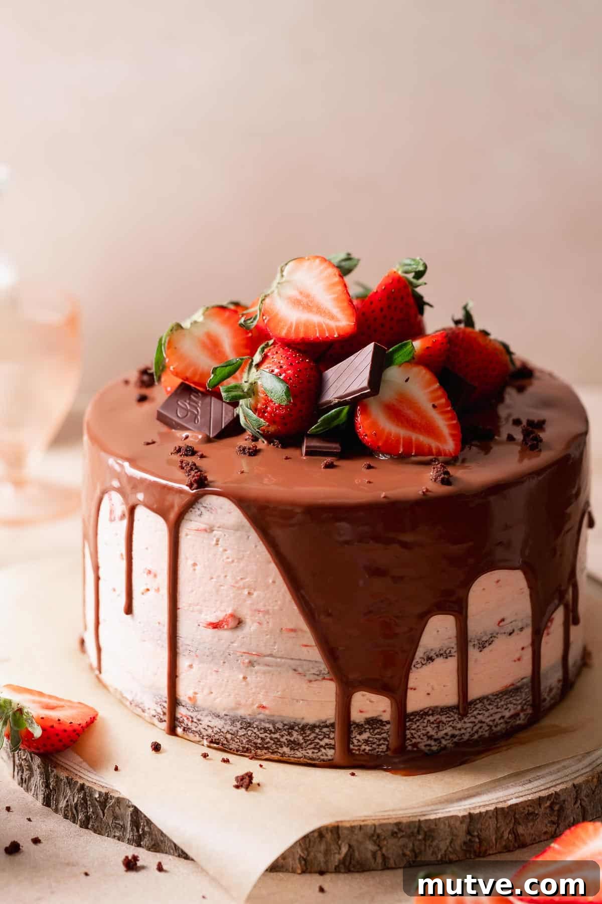 Chocolate Strawberry Layer Cake Recipe 4 Chocolate strawberry cake with fresh strawberries and ganache on a wooden cake board.