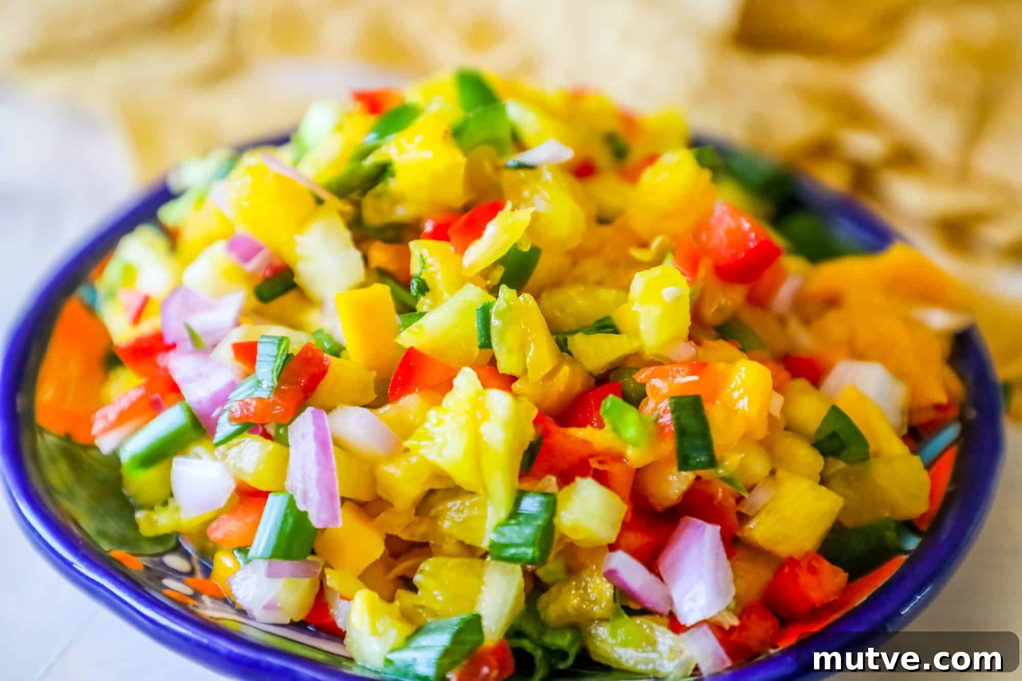 Spicy Pineapple Mango Salsa Recipe 3 bowl with pineapple, jalapeno, red onion, and green onions, chips behind it