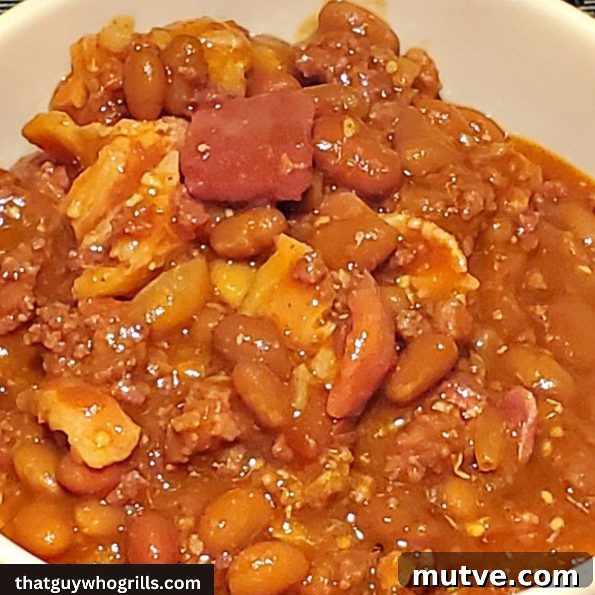 Smoked Loaded Baked Beans Recipe in a Cast Iron Dutch Oven 5 Smoked Loaded baked beans in white bowl