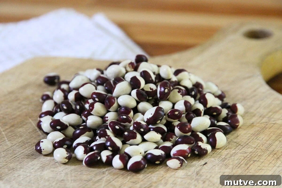 A pile of dried shelling beans on a wooden kitchen cutting board, ready for cooking. 