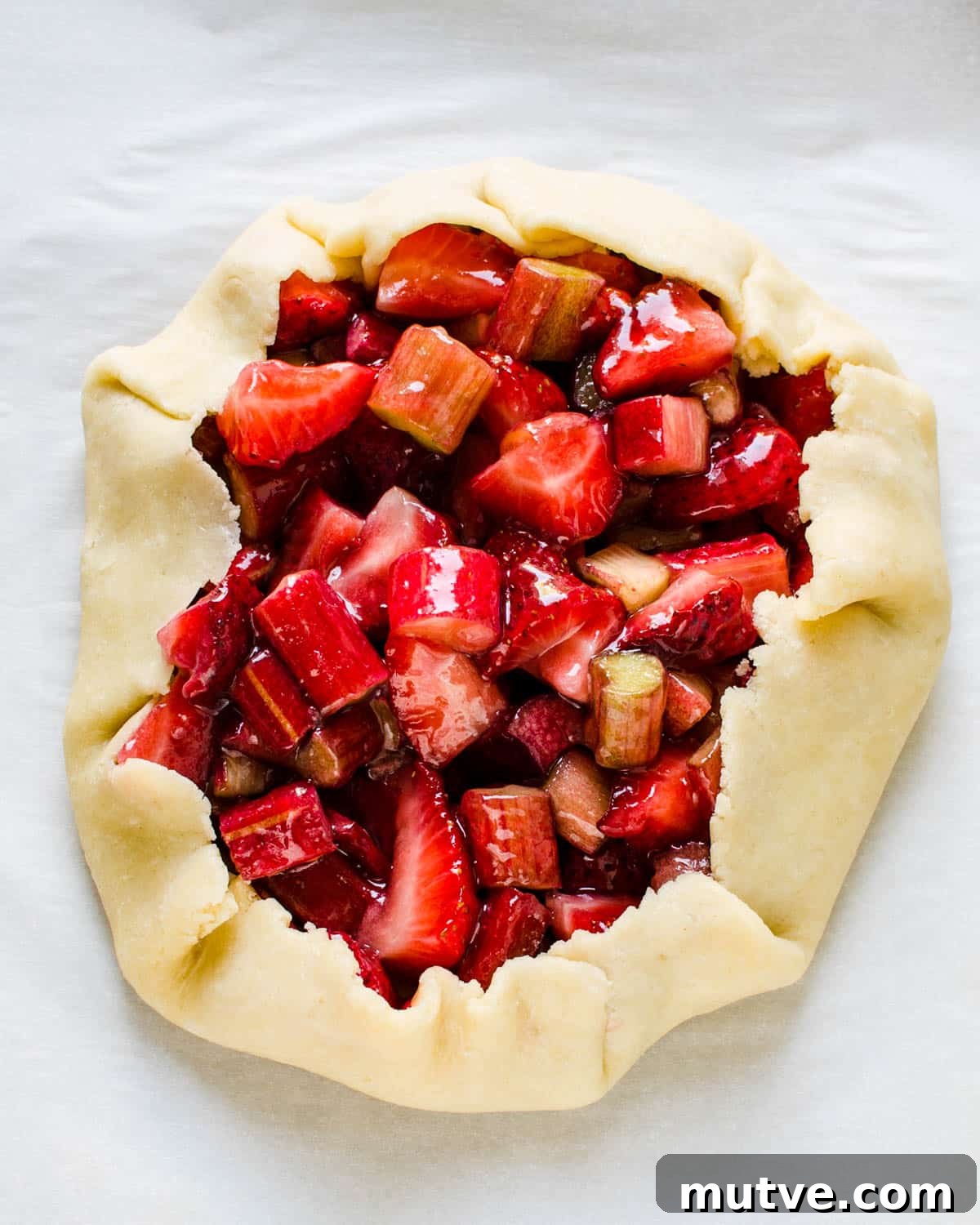 Rustic Strawberry Rhubarb Galette with Flaky Crust 11 Folding the edges of pastry around the fruit.