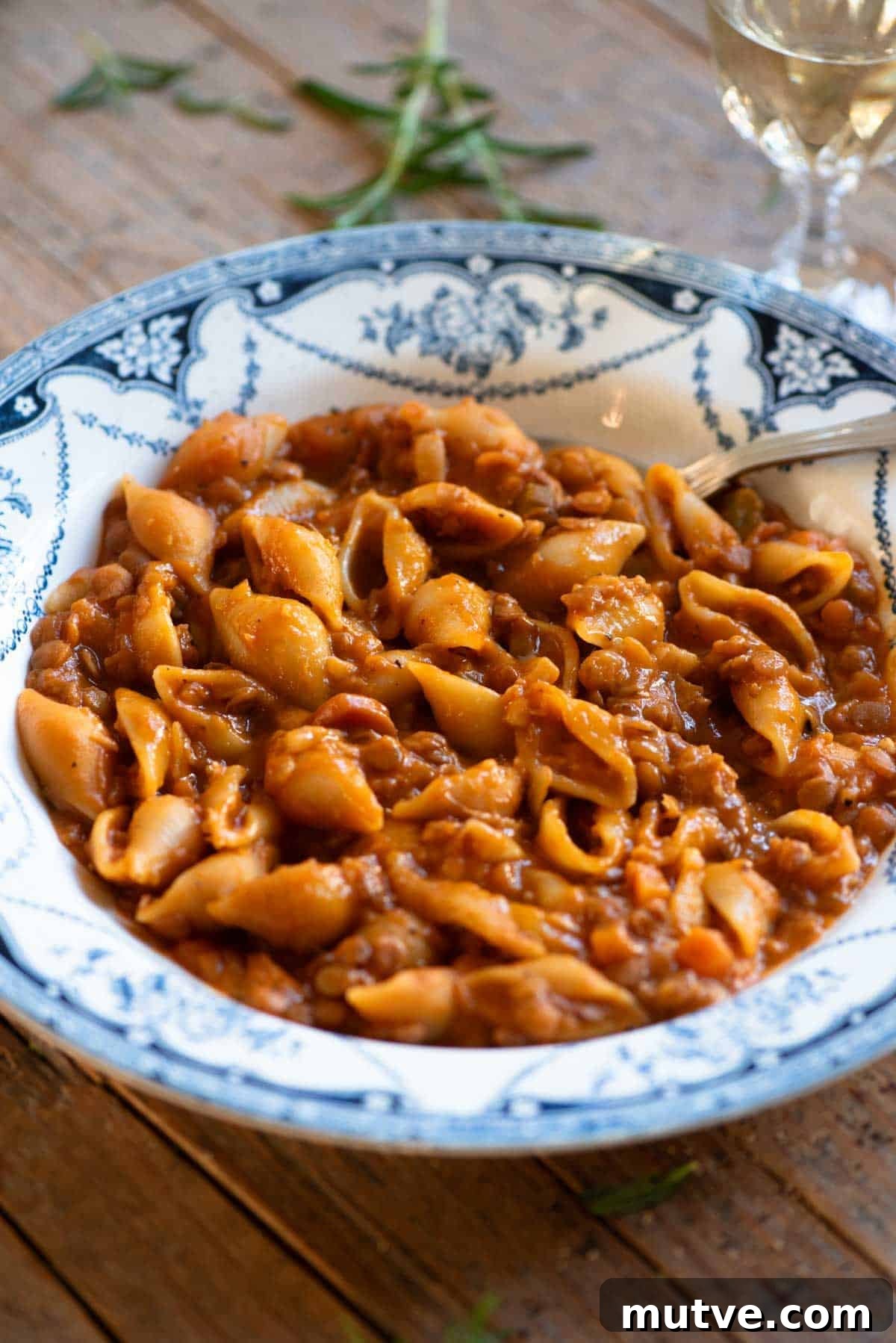 Pasta e Lenticchie Recipe: Authentic Italian Lentil Pasta 6 A close up of pasta and lentils in a blue vintage style bowl with a spoon.
