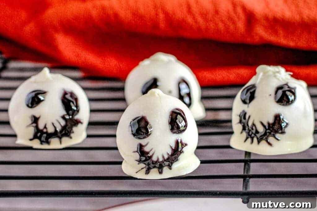 29 Halloween Treats That Beat Your Trick-or-Treat Candy 25 Four pieces of Skeleton Oreo Cookie Balls on a rack.