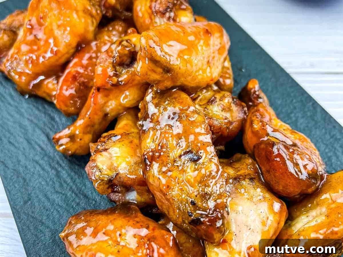 29 Halloween Treats That Beat Your Trick-or-Treat Candy 5 Smoked and glazed peach-chipotle chicken wings on a black plate.