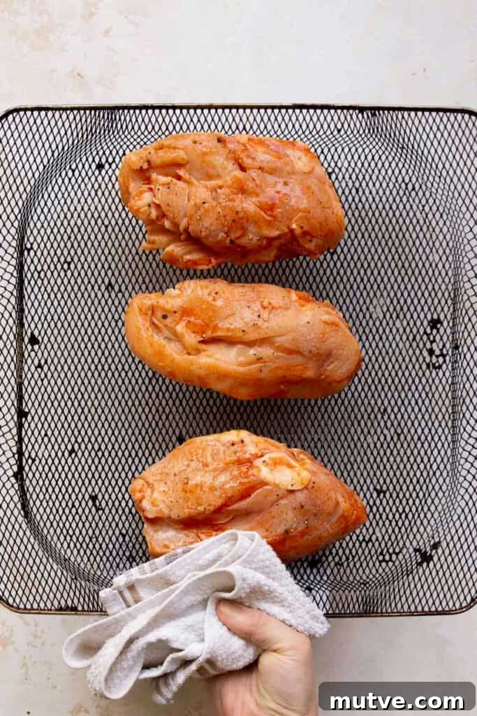 Air Fryer BBQ Chicken Breasts Recipe 5 three seasoned chicken breasts in an air fryer basked before frying