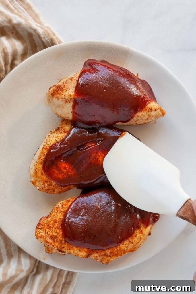 Air Fryer BBQ Chicken Breasts Recipe 6 covering cooked air fryer chicken breasts in barbecue sauce