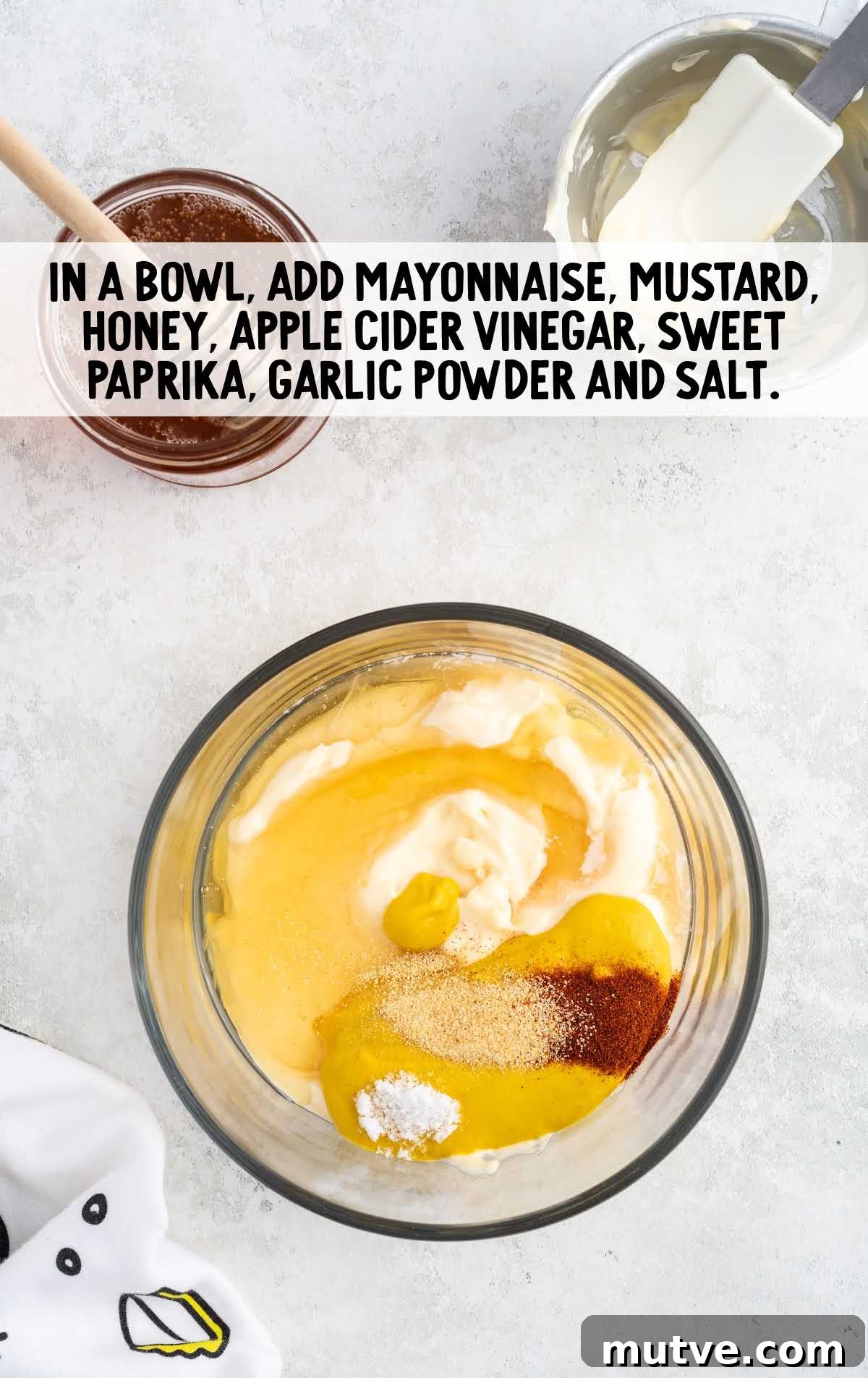 Homemade Honey Mustard Dipping Sauce 4 mayonnaise, mustard, honey, apple cider vinegar, sweet paprika, garlic powder, and salt folded in a bowl