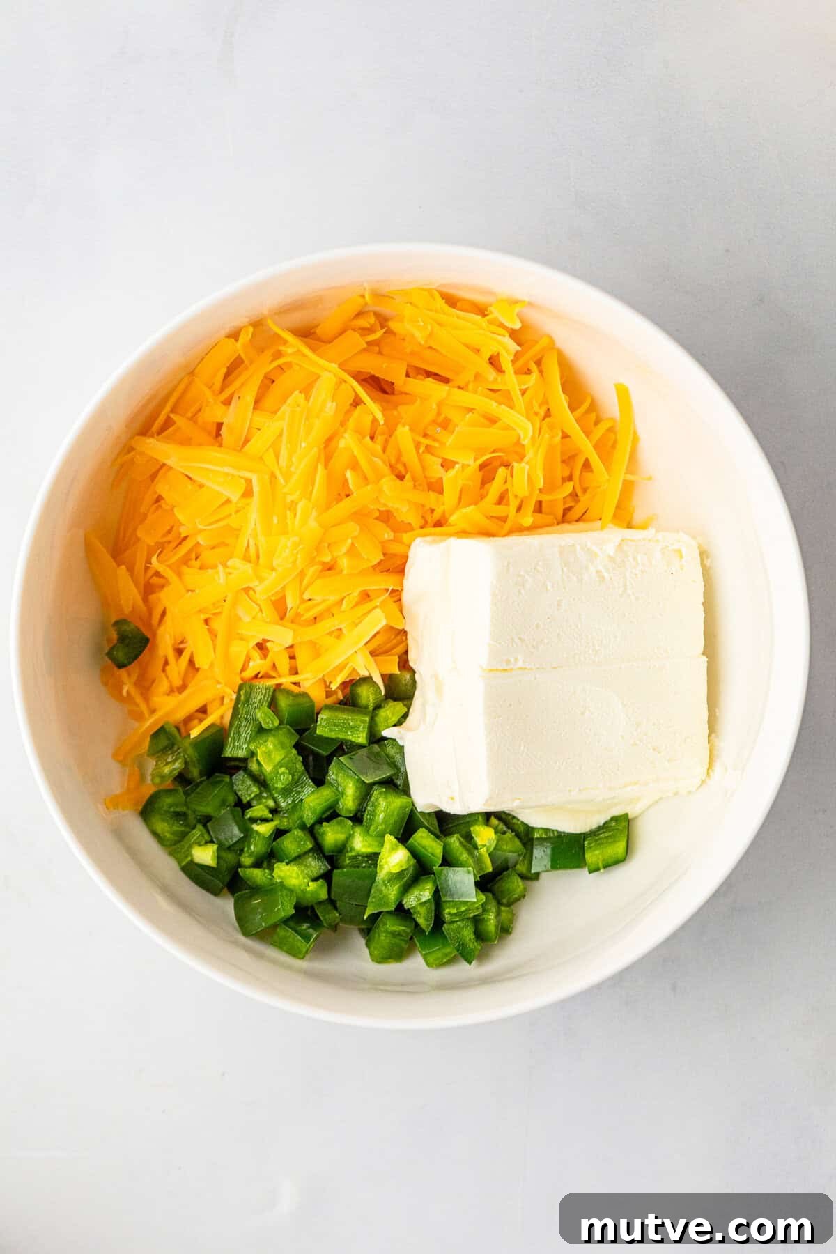 Juicy Jalapeno Popper Stuffed Burger with Bacon and Cream Cheese 4 Cheeses and jalapenos in small mixing bowl for Jalapeno Popper Stuffed Burger recipe