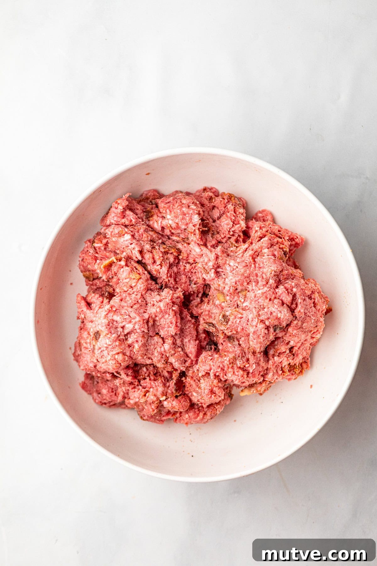 Juicy Jalapeno Popper Stuffed Burger with Bacon and Cream Cheese 6 Seasoned ground beef in white mixing bowl for Jalapeno Popper Stuffed Burger