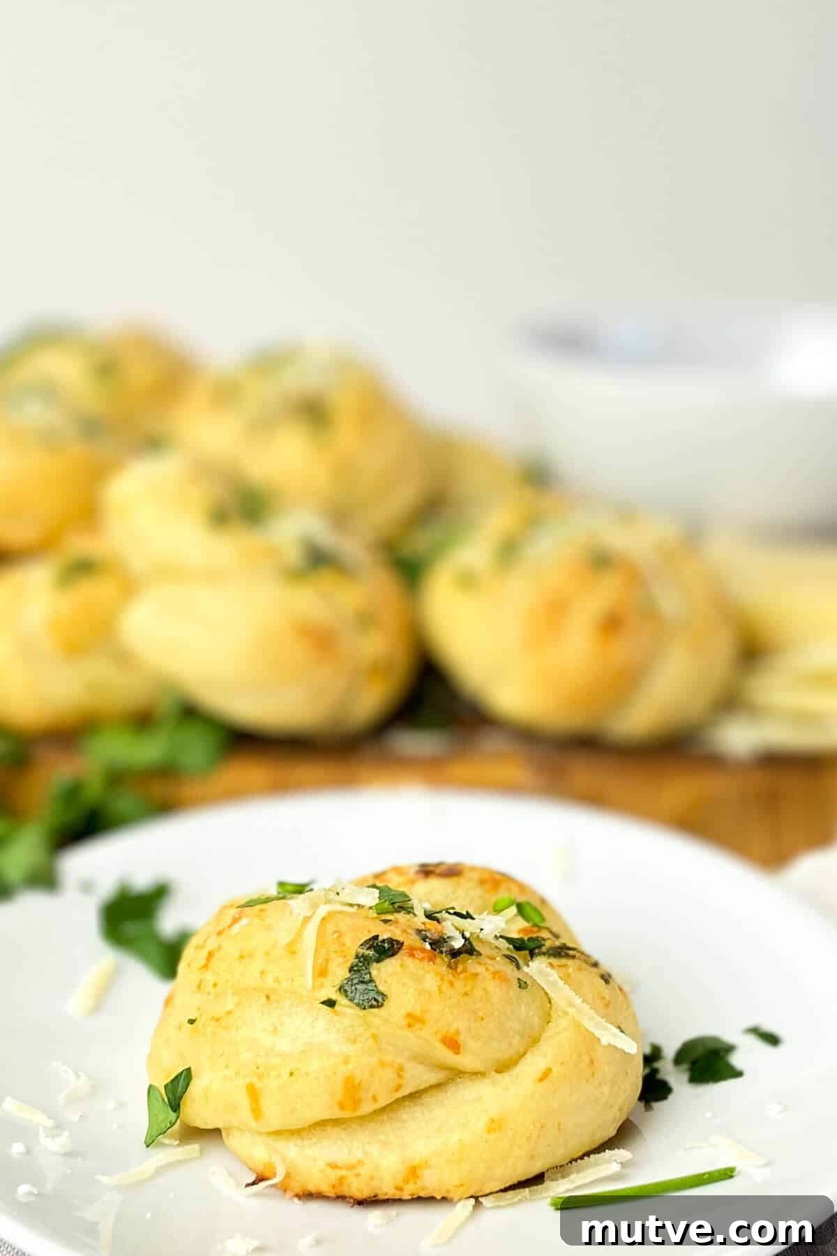 Homemade Garlic Knots Recipe with Herb Butter 2 Garlic knot on a plate.