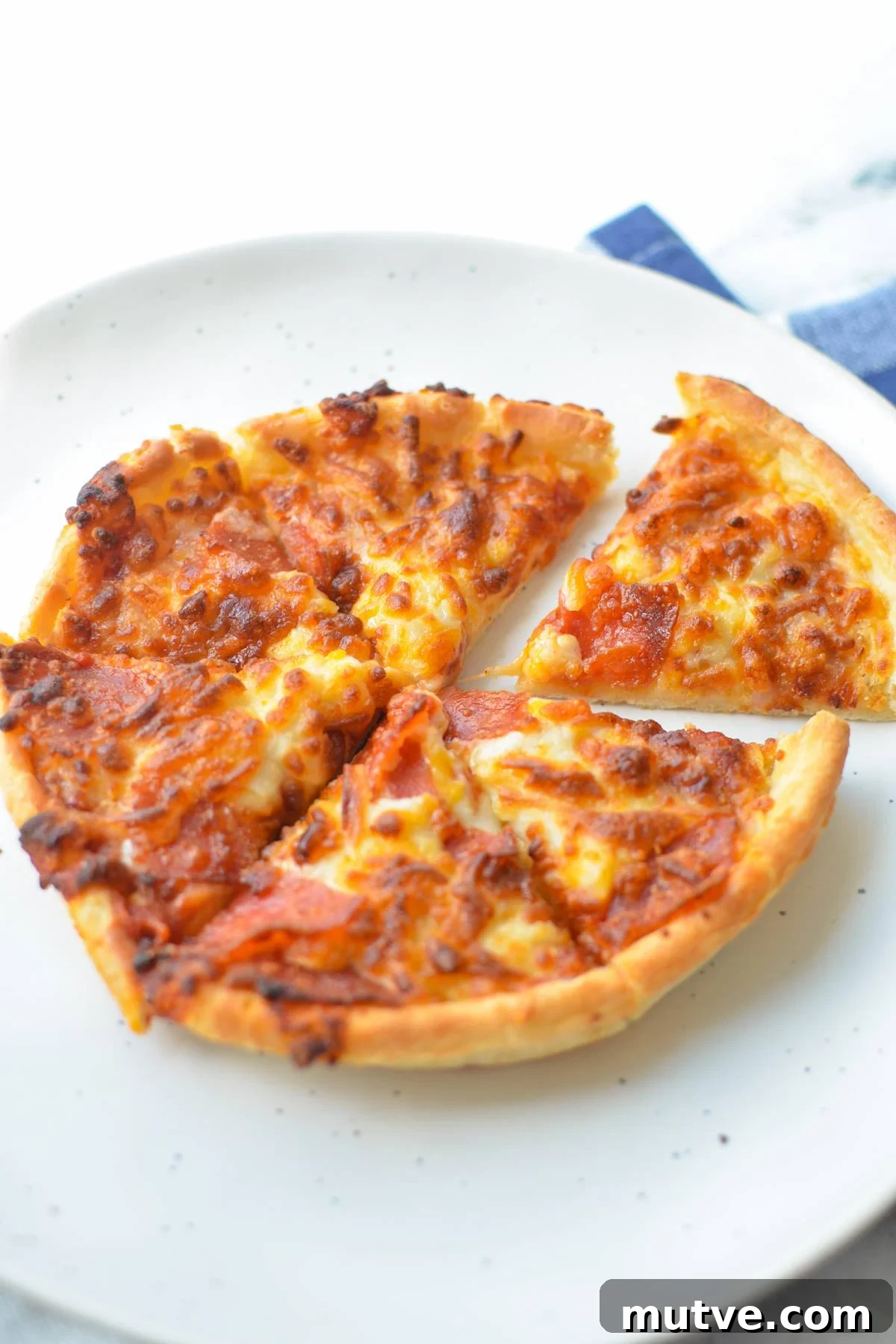Crispy Frozen Mini Pizzas in the Air Fryer 7 A mini pizza on a plate, cut into 6 slices.