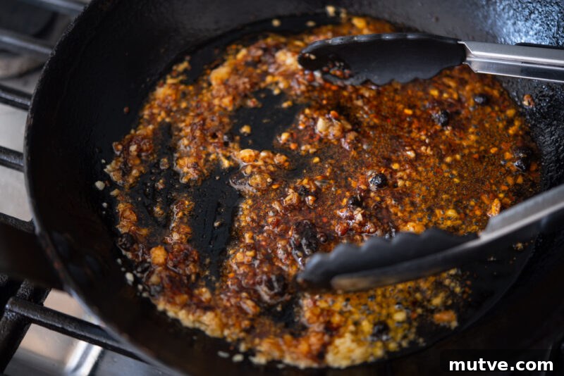 Quick Chili Garlic Shrimp with Chili Crisp Recipe 5 Chili crisp and garlic are fried together in oil in a skillet.