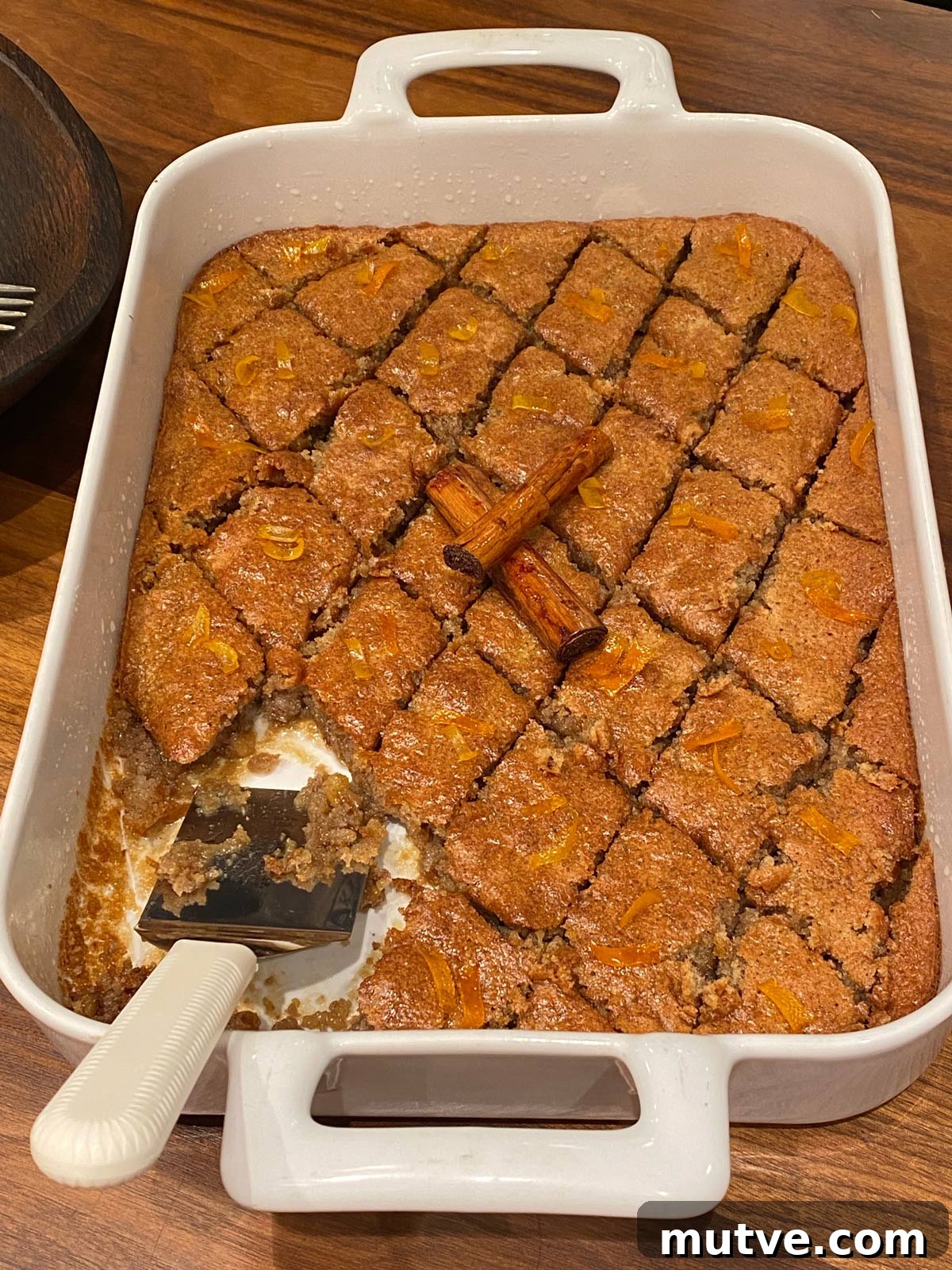 Tishpishti Honey Almond Cake with Citrus Syrup 19 Tishpishti cake cooked and being served from a white rectangular baking pan.
