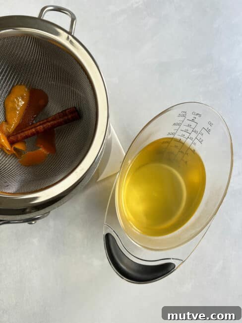Tishpishti Honey Almond Cake with Citrus Syrup 7 Syrup in a measuring cup next to the strainer.