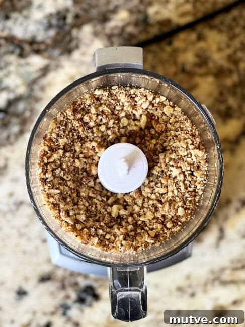 Tishpishti Honey Almond Cake with Citrus Syrup 8 Nuts already chopped in a food processor top down view.