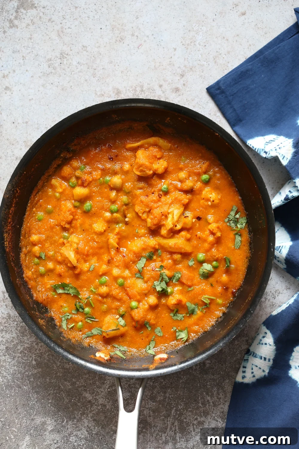 Coconut Korma with Cauliflower, Potato and Chickpeas Recipe 3 Vegetable Coconut Korma in Black skillet over concrete