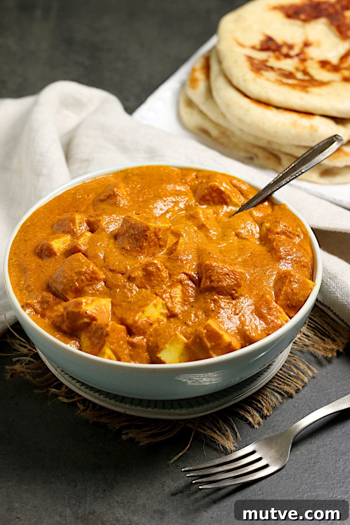 Butter paneer in a pale blue bowl.