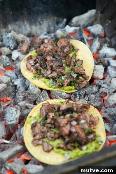Grilled Steak Tacos with Mexican Street Corn and Cotija 9 A close up of dirty steak tacos assembled and crisping up on top of the coals
