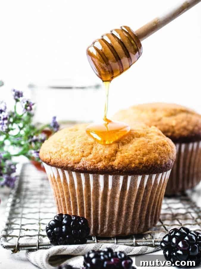 Homemade Honey Corn Muffins Recipe 2 Corn muffins being drizzled with honey