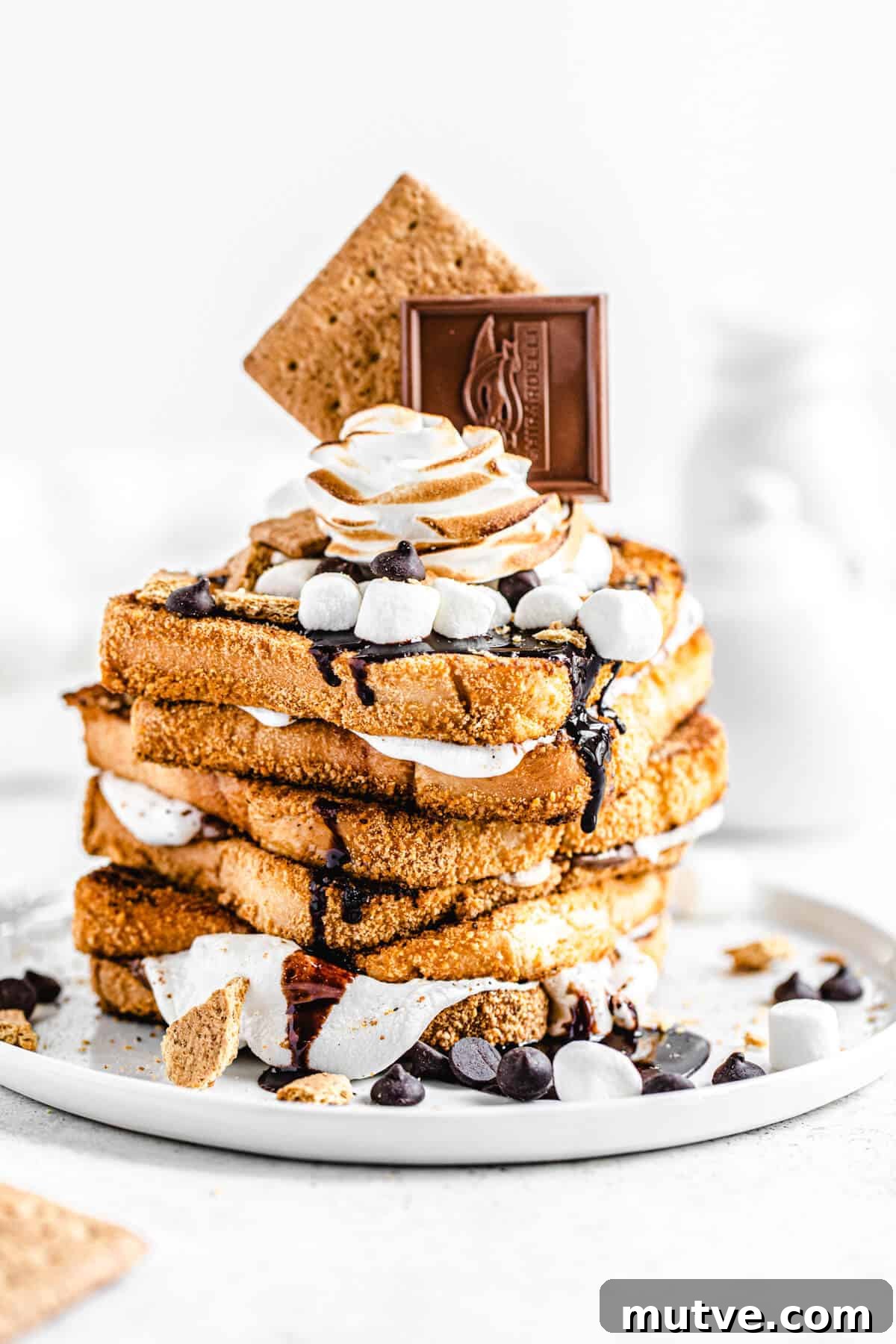 Campfire S'mores French Toast with Chocolate and Marshmallows 2 stack of marshmallow filled graham cracker French toast topped with chocolate, marshmallows and graham crackers