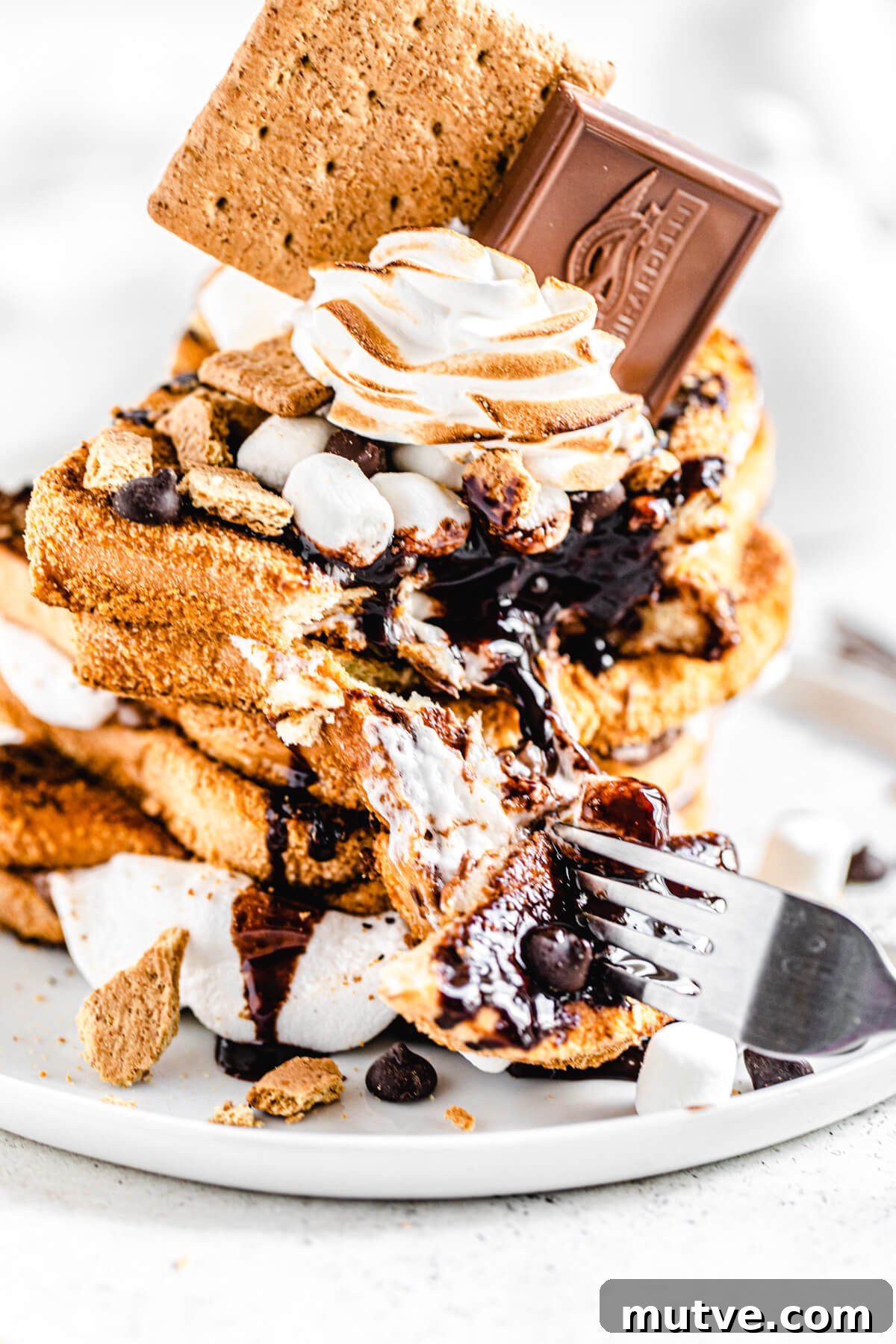 Campfire S'mores French Toast with Chocolate and Marshmallows 4 stack of s'mores flavoured French toast with a piece taken out