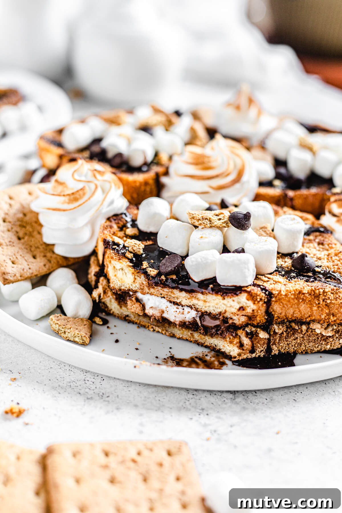 Campfire S'mores French Toast with Chocolate and Marshmallows 8 French toast on a plate with bite removed to show chocolate marshmallow filling