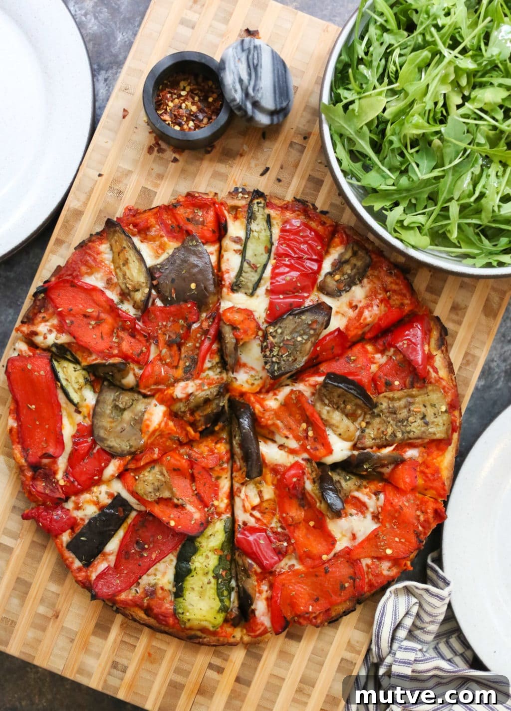 Copycat Trader Joe's Grilled Vegetable Flatbread Recipe 2 Grilled Vegetable Flatbread sliced with a side salad and serving plates.