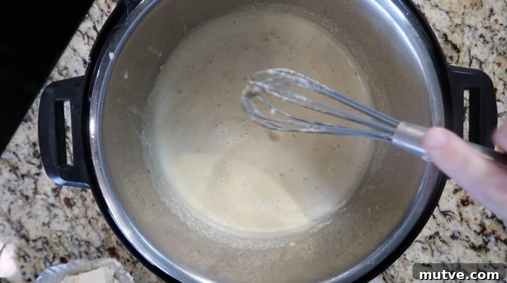 Creamy Instant Pot Chicken Baconara Pasta 23 Whisking sauce.