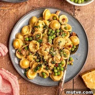 A blue plate of pasta with peas.