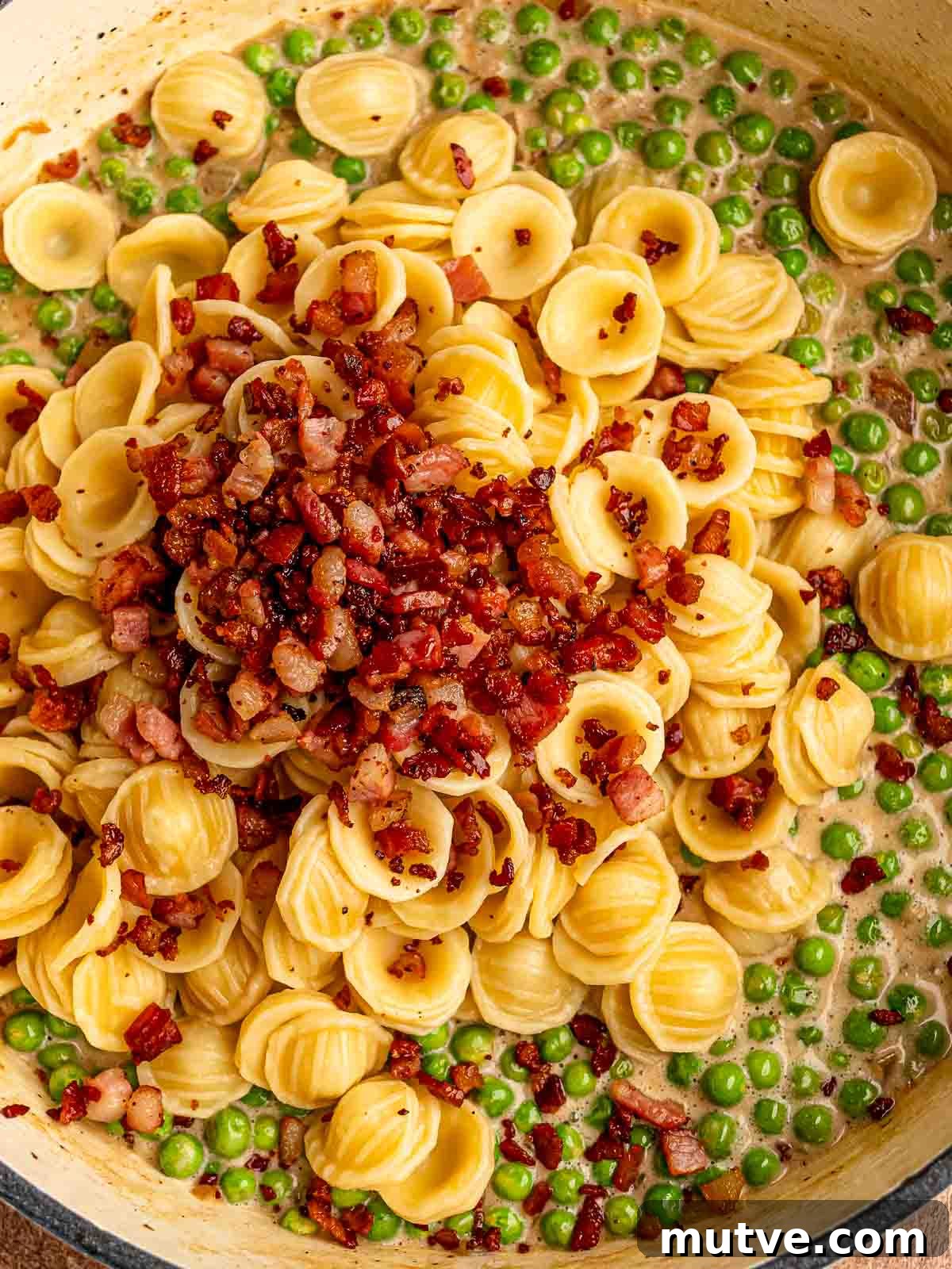 Bacon in a pan with pasta before mixing.