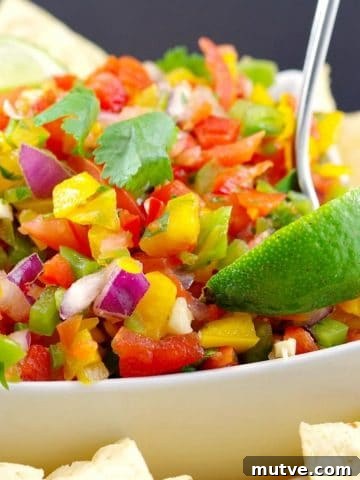 Chicken Tortilla Pinwheels Recipe: Cheesy Party Appetizer 18 Pico de Gallo Salsa in a white bowl with a spoon, wedge of lime and tortilla chips on the side