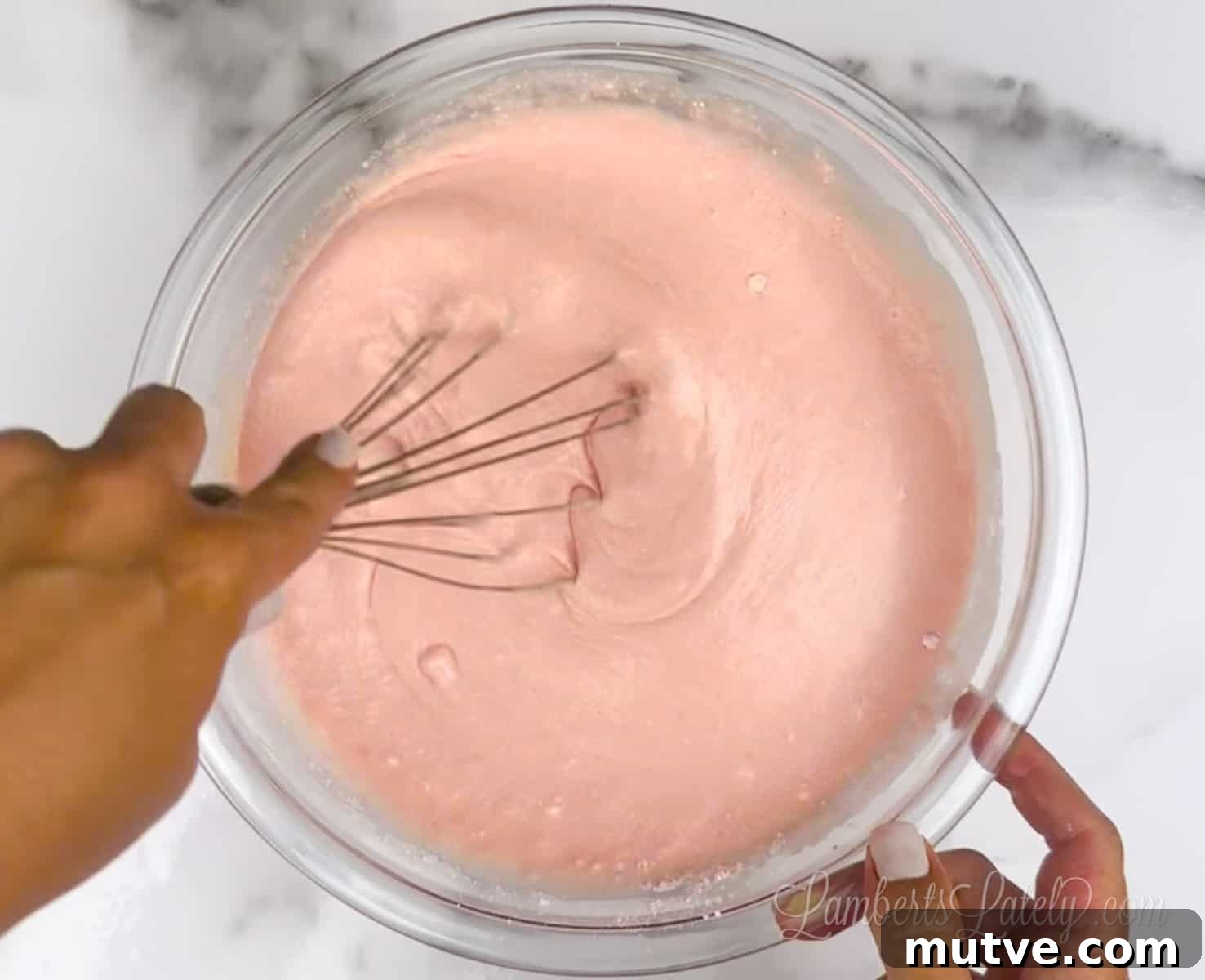 mixing pink cake mix pancake batter in a bowl.